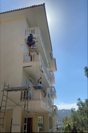 Operarios de Decofam trabajando en cuerdas en fachada de edificio